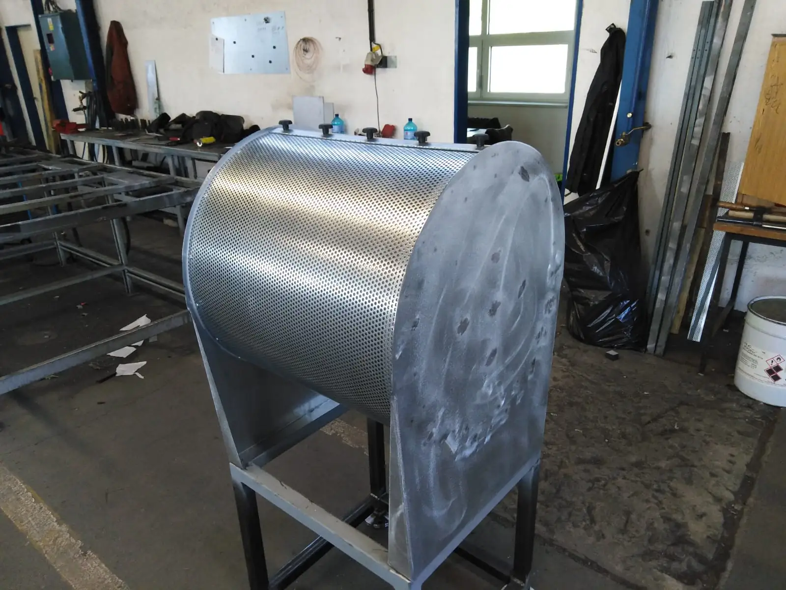 Custom round industrial silencer made of metal on a steel support frame
